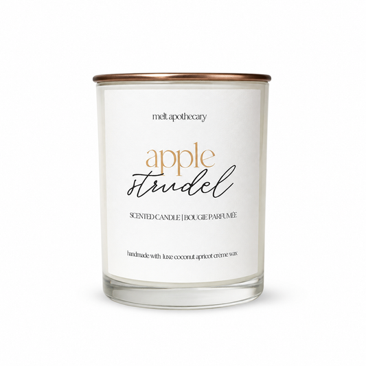 A glass jar candle with a white label reading 'melt apothecary apple spudel' and a metallic rose gold lid, shown on a clean white background.