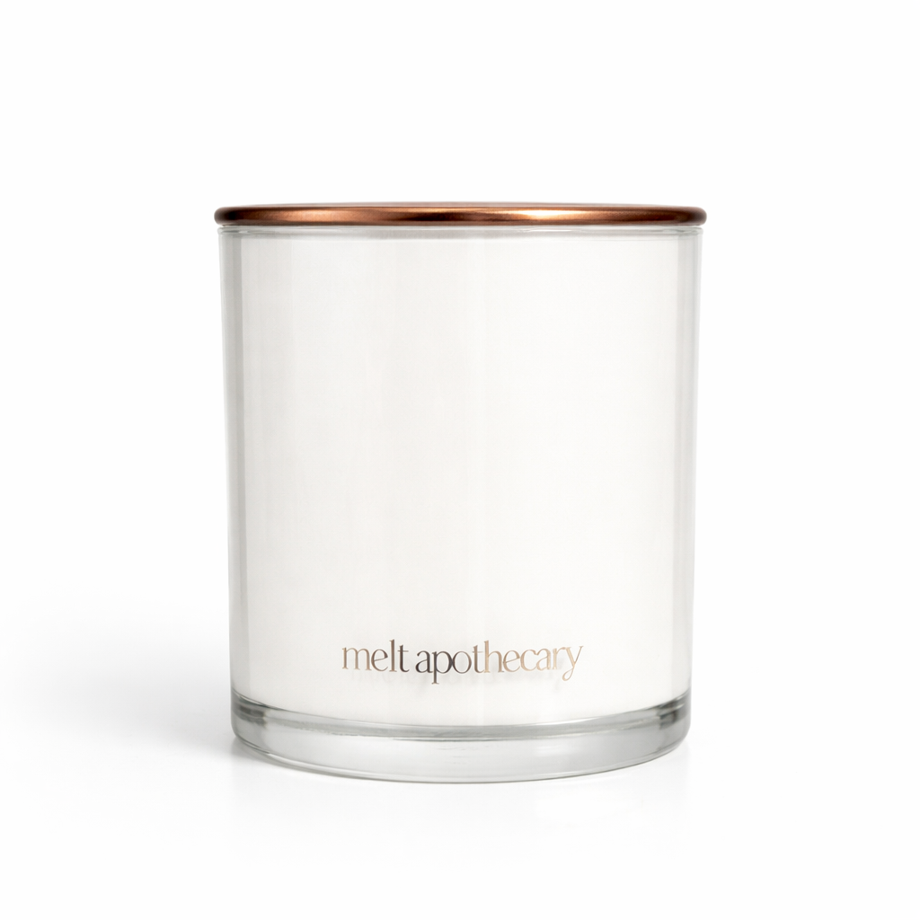 Clear glass candle with a copper lid on a white background, featuring the brand 'melt apothecary'.